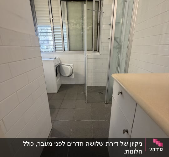 חדר אמבטיה עם מקלחון ומכונת כביסה